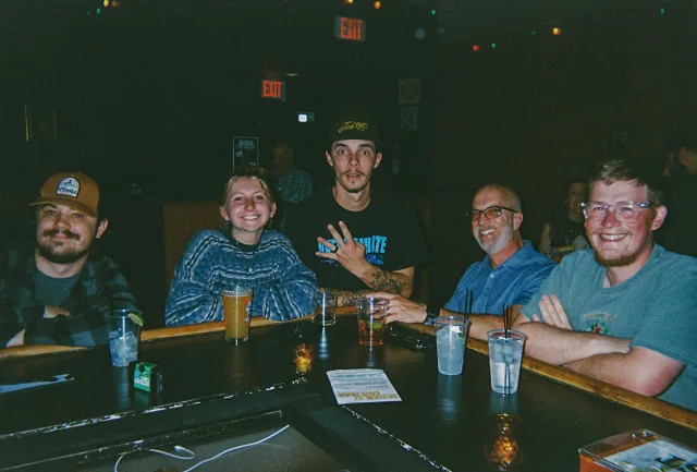 Five guests gathered with drinks at the Easy Tiger bar.