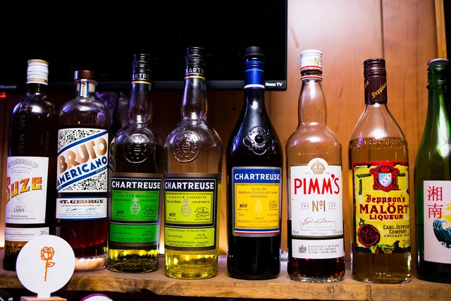 A shelf of assorted spirits, Chartreuse, Pimm’s and other liqueurs.