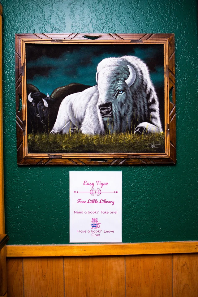 Tiger artwork and a handwritten notice in a green alcove.